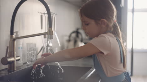 preschooler-girl-is-washing-hands-in-kitchen-after-cooking-daughter-is-helping-out-around-home